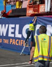 A banner that reads “Welcome to the Pacific Northwest” is installed on a shipping container at Terminal 46 in Seattle.